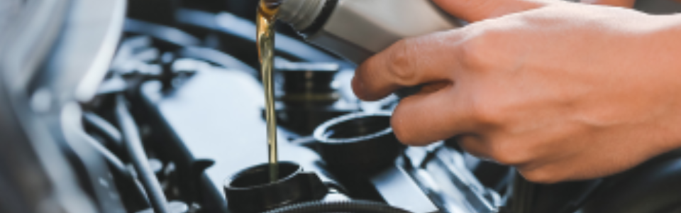 A hand of someone putting oil in a car